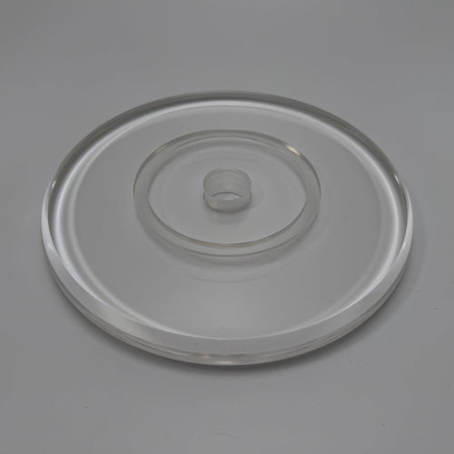 Runde Acryldisc Ø 20 cm aus klarem Acrylglas, schräg von oben – umlaufende Rille für eine Säule Ø 10 cm, in der Mitte eine Bohrung mit erhabenem Rand, neutraler grauer Hintergrund