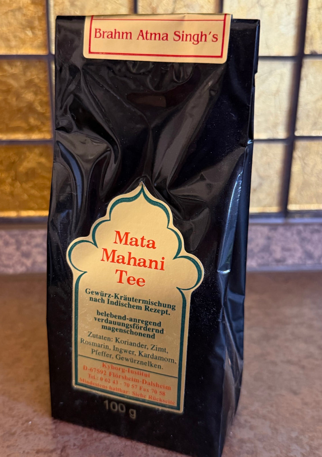 Mata Mahani Tee in der schwarzen Standpackung zu 100 g – goldenes Etikett in Bogenform mit rotem Schriftzug, oben ein rot umrandetes Schild „Brahm Atma Singh’s“
